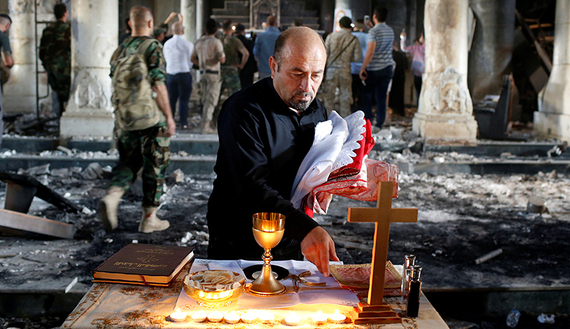 An Iraqi Christian prepares for the first Sunday mass at the Grand Immaculate Church since it was recaptured from Islamic State in Qaraqosh